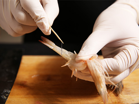 用剪刀将虾腔、虾须剪掉,用刀从虾腹部片一刀并剔去虾线;